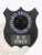 Close-up of a custom black shield metal badge for Ontario Provincial Police K-9 Unit, displaying the official crest and clear 'K-9 UNIT' label, attached with a safety pin.