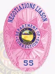 Custom BCAM pink oval metal badge with a central 7-point star for Indiana Department of Corrections, featuring blue lettering reading 'NEGOTIATIONS LIAISON' and badge number 55, attached with a safety pin.