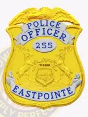 Gold shield-shaped police badge for Eastpointe PD with silver accent panels, eagle top design, central Michigan state emblem reading 'TUEBOR,' and identification number 255, equipped with safety pin.