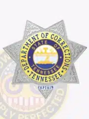 Tennessee Department of Corrections custom metal badge in a silver 7-point star shape with gold accent panels, featuring a blue and gold state seal with agricultural symbols at the center, bordered by "DEPARTMENT OF CORRECTIONS TENNESSEE," and marked "CAPTAIN" on the lower panel; fitted with a safety pin fastener.