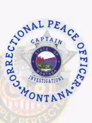 Montana Correctional Peace Officer custom badge in silver, shaped as a 5-point star with embossed detailing within a circular banner, the center seal showing "STATE OF MONTANA" with natural scenery, framed by blue text "CORRECTIONAL PEACE OFFICER MONTANA," and scroll banners indicating rank "CAPTAIN" and unit "INVESTIGATIONS"; fitted with safety pin fastener.