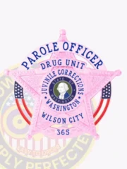 Custom BCAM pink 5-point star metal badge with a circular banner for Washington Juvenile Corrections, featuring embossed floral detailing on the star, a central blue and white circular seal with the text "STATE OF WASHINGTON," surrounded by blue text "PAROLE OFFICER JUVENILE CORRECTIONS WASHINGTON," and additional banners reading "DRUG UNIT" and "WILSON CITY" with badge number 365 at the bottom; includes a safety pin attachment.
