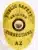 Custom gold oval metal badge for Public Safety Corrections in Arizona, featuring black lettering and the State of Arizona seal at the center, with a safety pin attachment on the back.