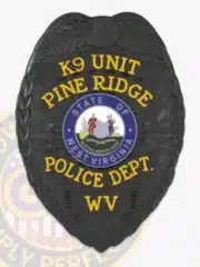 Custom black metal police badge featuring eagle design for Pine Ridge Police Department K9 Unit with secure safety pin attachment