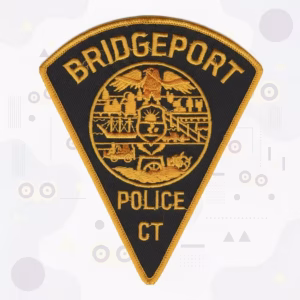 Black triangle police patch with an industrial city seal