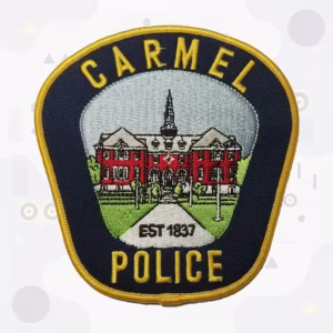 Police shield patch with a historic red brick city hall
