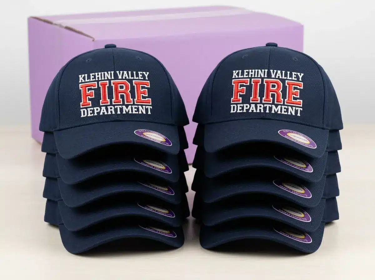 Stacked custom embroidered fire department caps from a completed bulk order, ready to ship